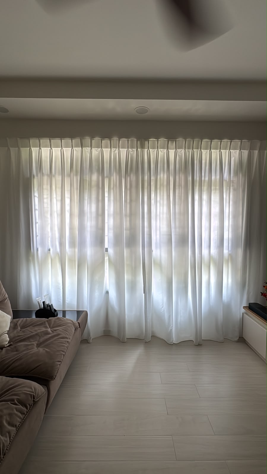 Soft white curtains framing a bright living room